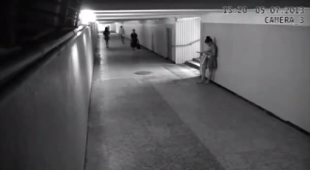 Kvinnan står och väntar i tunnelbanan.